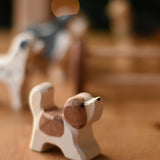 An Ostheimer small St Bernard dog wooden toy figure placed on a wooden surface. These wooden figures are part of a wide range of expertly hand crafted wooden toys here at Babipur. 