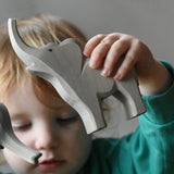 Ostheimer small trumpeting elephant wooden toy figure in a child's hand.