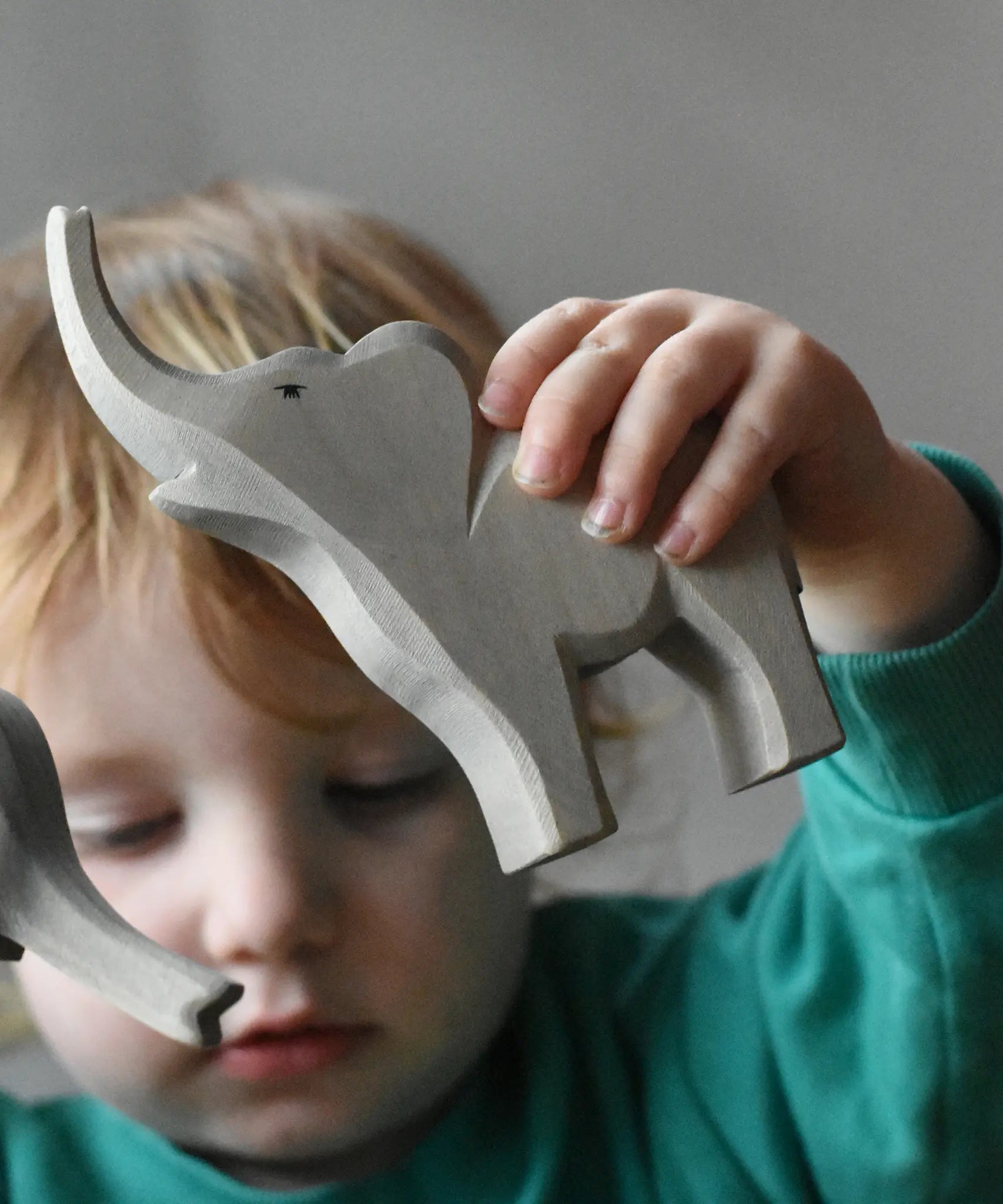 Ostheimer small trumpeting elephant wooden toy figure in a child's hand.