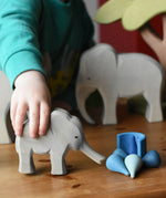 Ostheimer small elephant with trunk out in a child's hand and Grapat water mandala pieces.