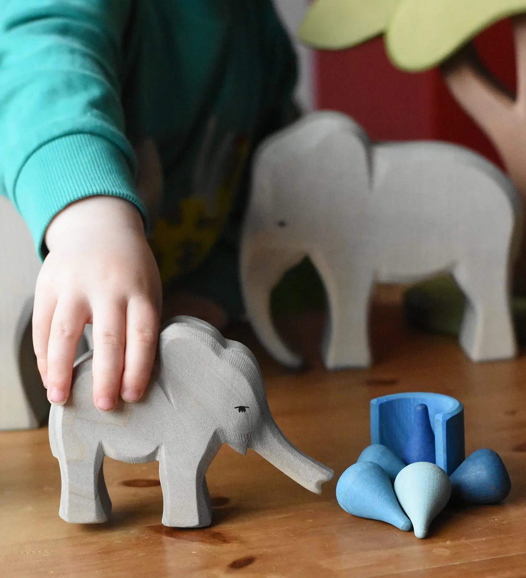 Ostheimer small elephant with trunk out in a child's hand and Grapat water mandala pieces.
