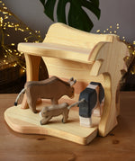 Ostheimer small wooden toy stable with cow figures placed inside. 