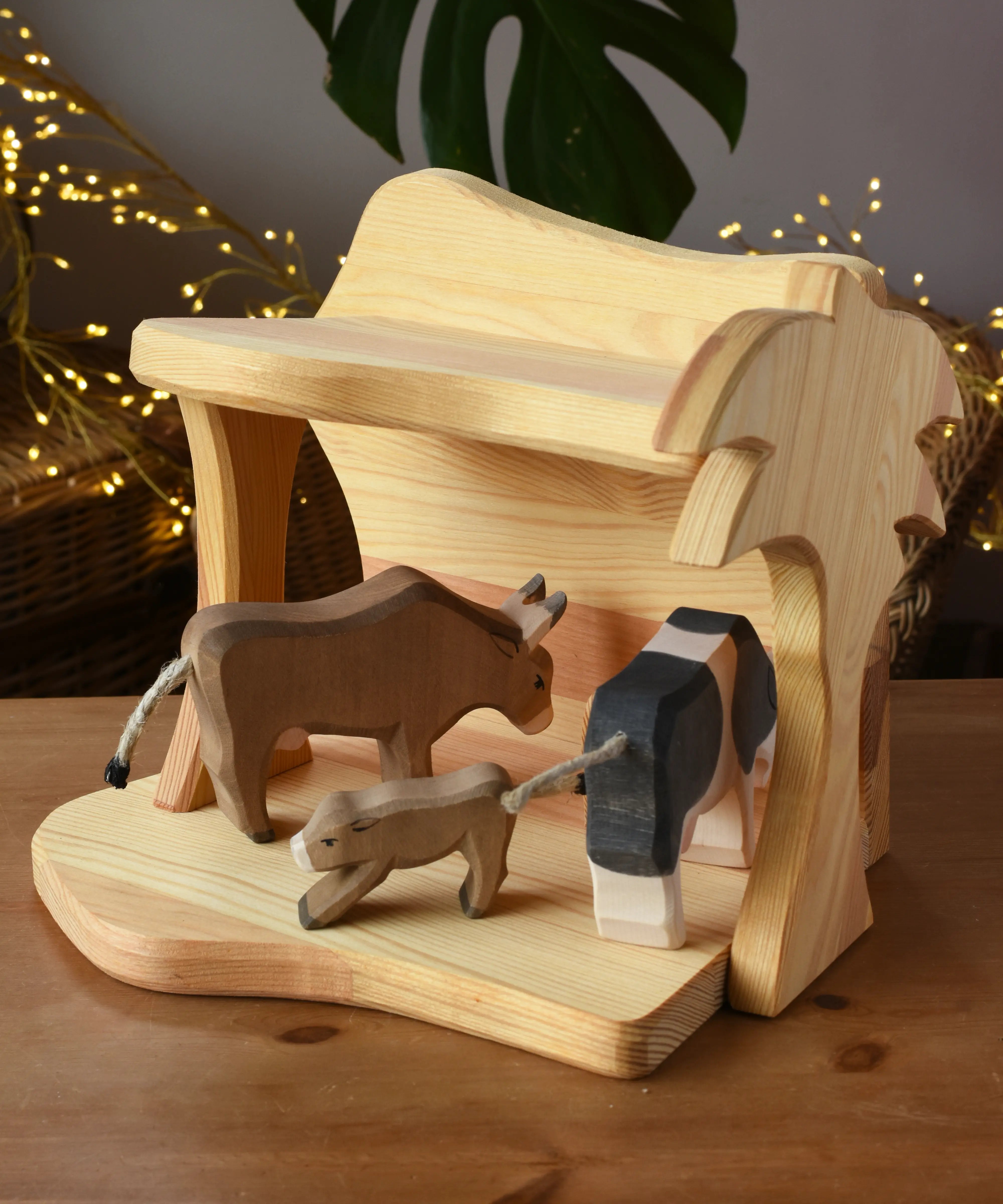 Ostheimer small wooden toy stable with cow figures placed inside. 