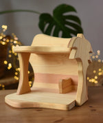 Ostheimer small wooden toy stable placed on a wooden surface.