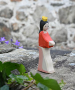 Ostheimer Snow White wooden toy figure placed on a stone wall outdoors. 