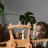 Ostheimer Wooden Stage Coach toy with princess figures placed inside and a frog king placed at the front.