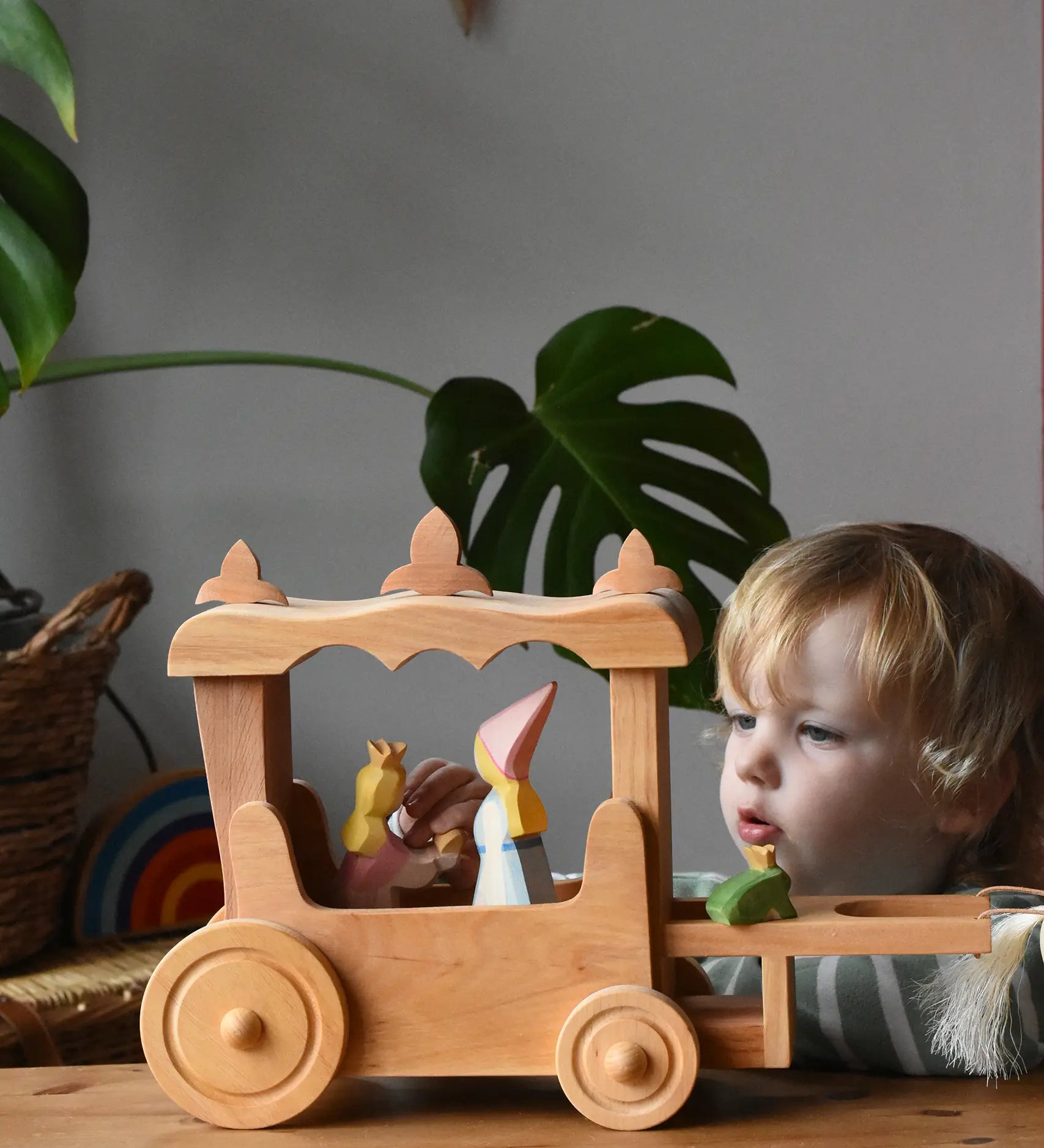 Ostheimer Wooden Stage Coach toy with princess figures placed inside and a frog king placed at the front.