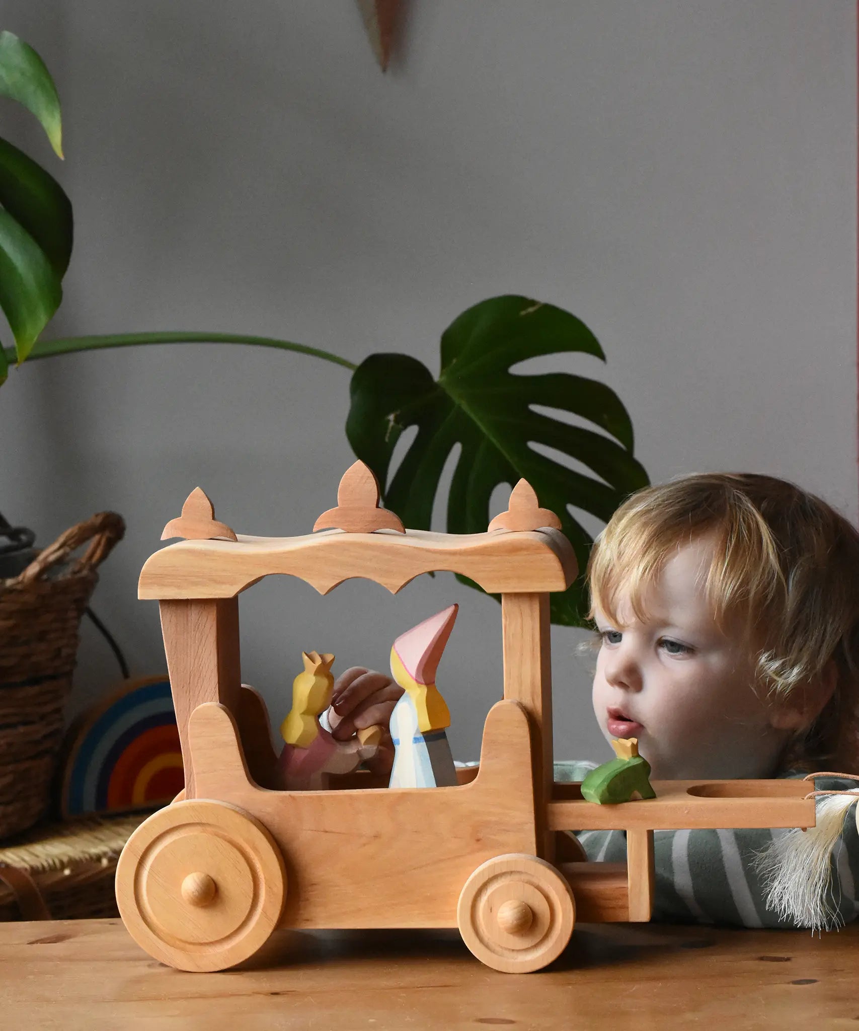 Ostheimer Wooden Stage Coach toy with princess figures placed inside and a frog king placed at the front.