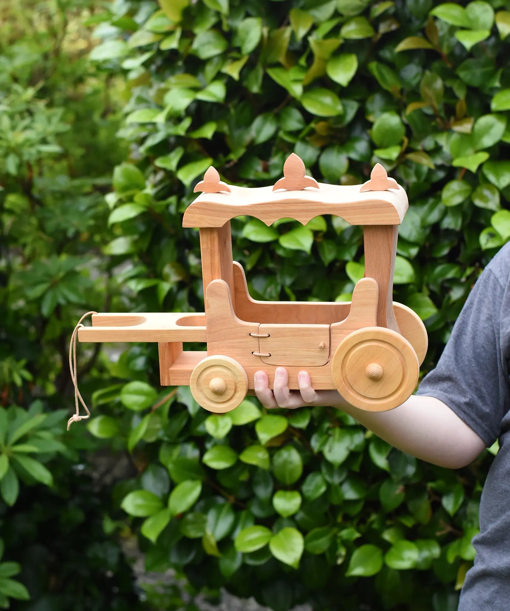 Ostheimer wooden stage coach toy in a child's hand. 