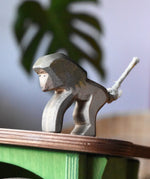 Ostheimer standing baboon wooden toy animal figure placed on the roof of the green hutch.