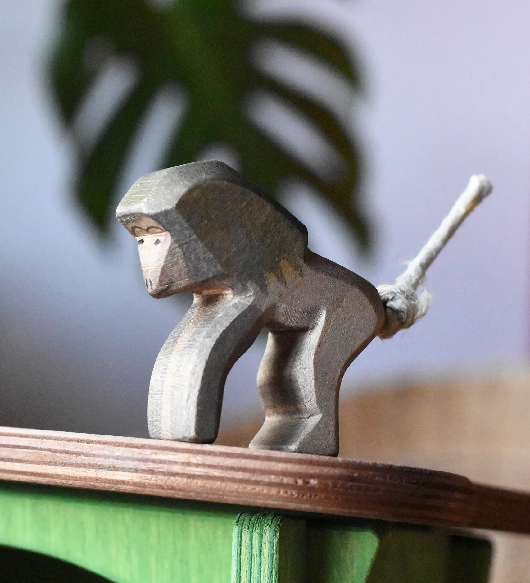 Ostheimer standing baboon wooden toy animal figure placed on the roof of the green hutch.
