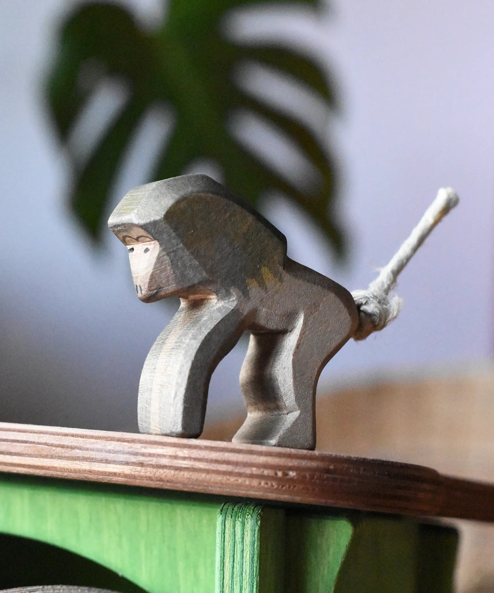 Ostheimer standing baboon wooden toy animal figure placed on the roof of the green hutch.