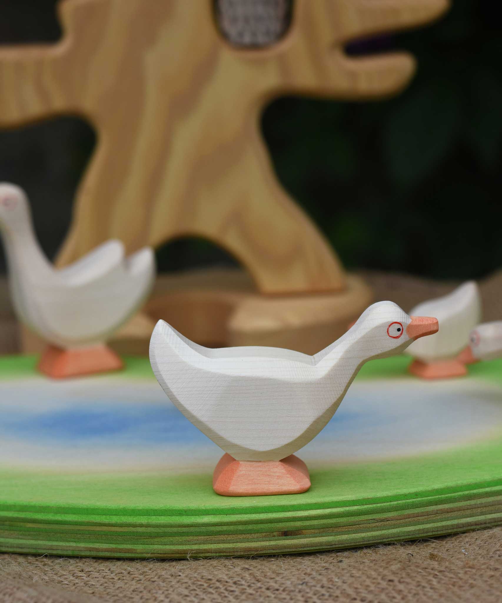 Ostheimer standing goose wooden toy figure placed on a wooden pond scene piece. This wooden toy figure is part of a large collection of expertly handcrafted wooden toys here at Babipur.