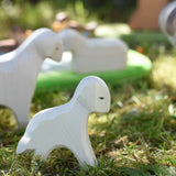 Ostheimer standing lamb wooden toy figure placed on grass in the Babipur garden.