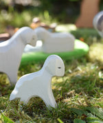 Ostheimer standing lamb wooden toy figure placed on grass in the Babipur garden.