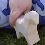 Ostheimer standing lamb wooden toy figure in a child's hand.