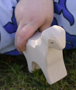 Ostheimer standing lamb wooden toy figure in a child's hand.