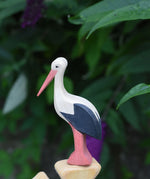 An Ostheimer stork wooden toy figure placed on the top of an Ostheimer bird tree. 