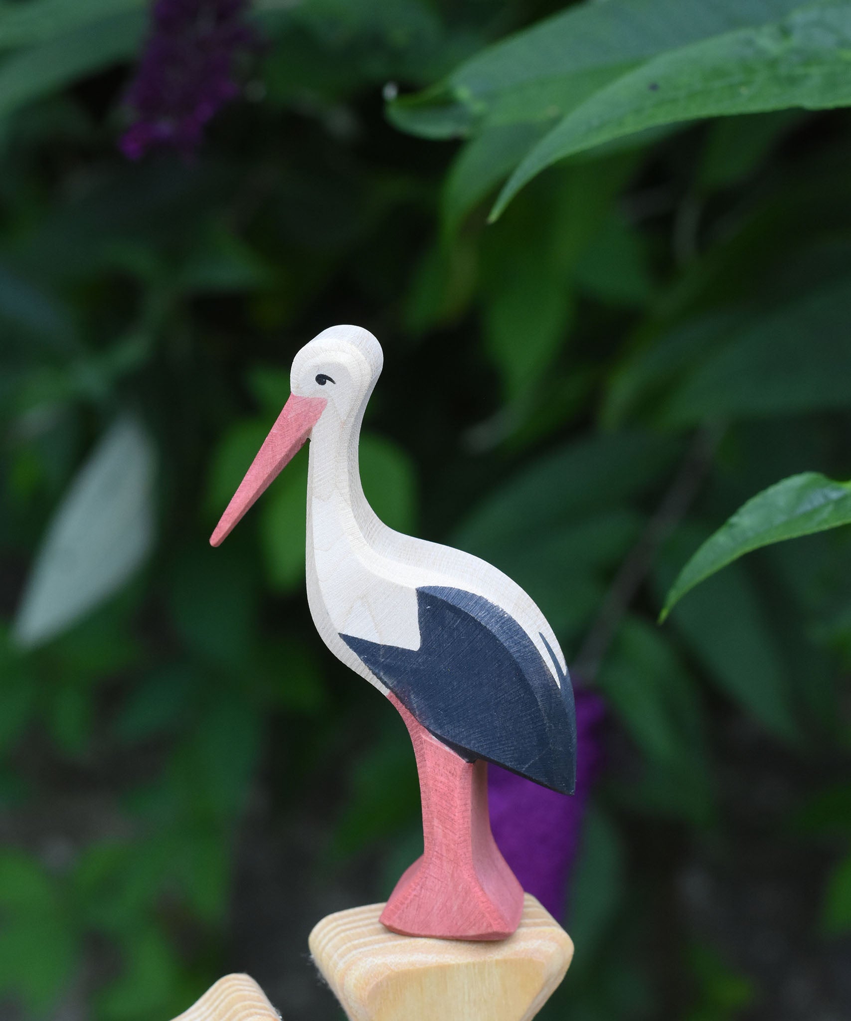 An Ostheimer stork wooden toy figure placed on the top of an Ostheimer bird tree. 