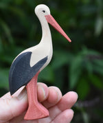 An Ostheimer stork toy held up in an adult's hand.