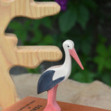An Ostheimer stork wooden toy figure placed on top of a pile of books.