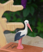 An Ostheimer stork wooden toy figure placed on top of a pile of books.