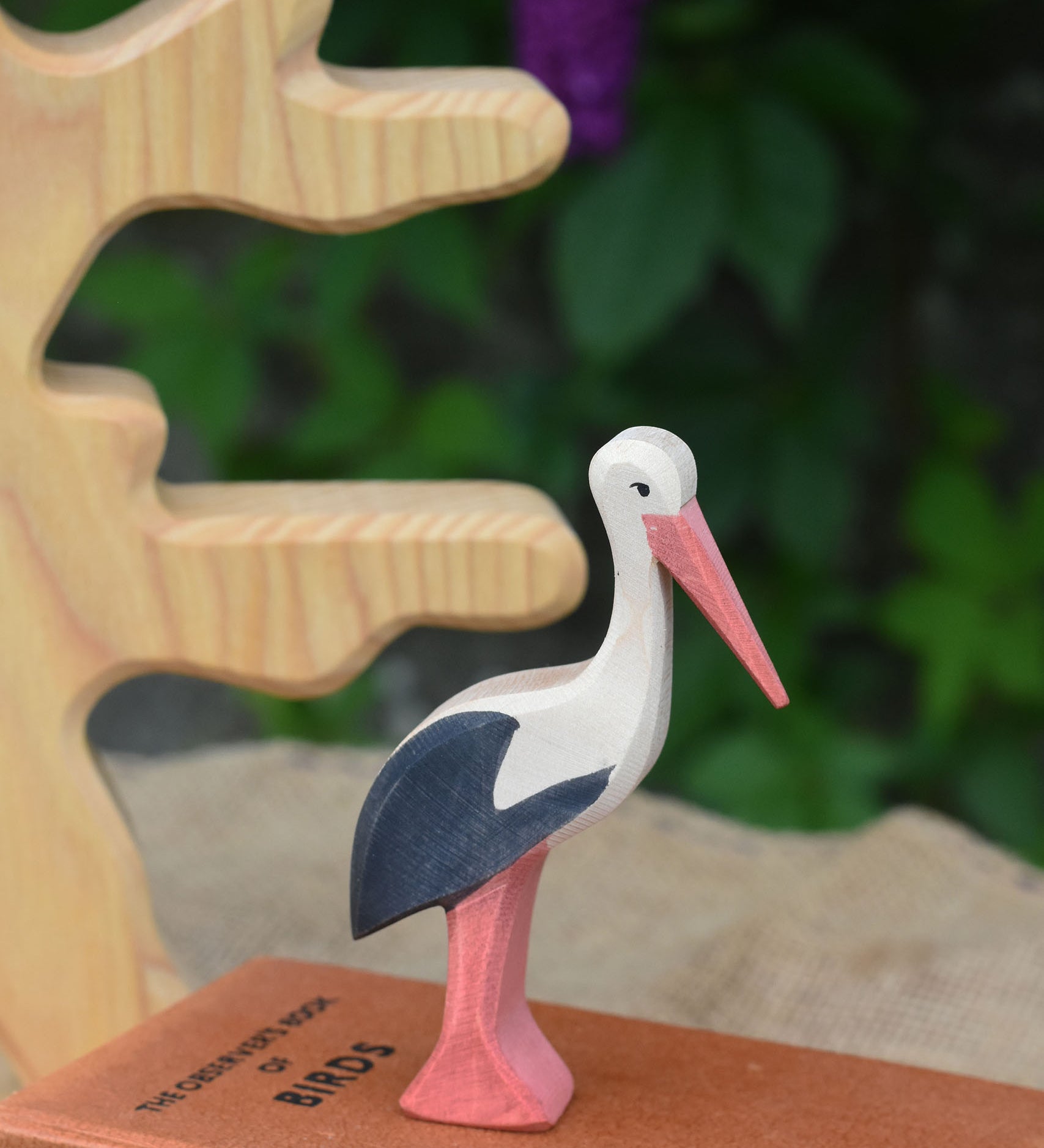 An Ostheimer stork wooden toy figure placed on top of a pile of books.