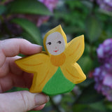 An Ostheimer Sunflower Flower Child being held in an adult's hand to show scale. This wooden figure is part of a large range of expertly hand crafted, Waldorf inspired, wooden toys here at Babipur. 