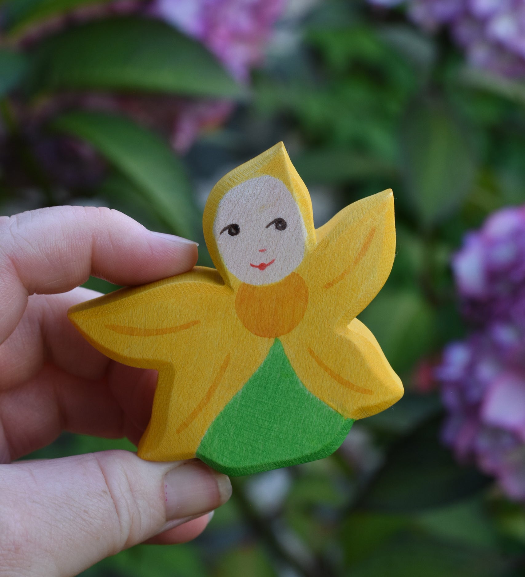 An Ostheimer Sunflower Flower Child being held in an adult's hand to show scale. This wooden figure is part of a large range of expertly hand crafted, Waldorf inspired, wooden toys here at Babipur. 