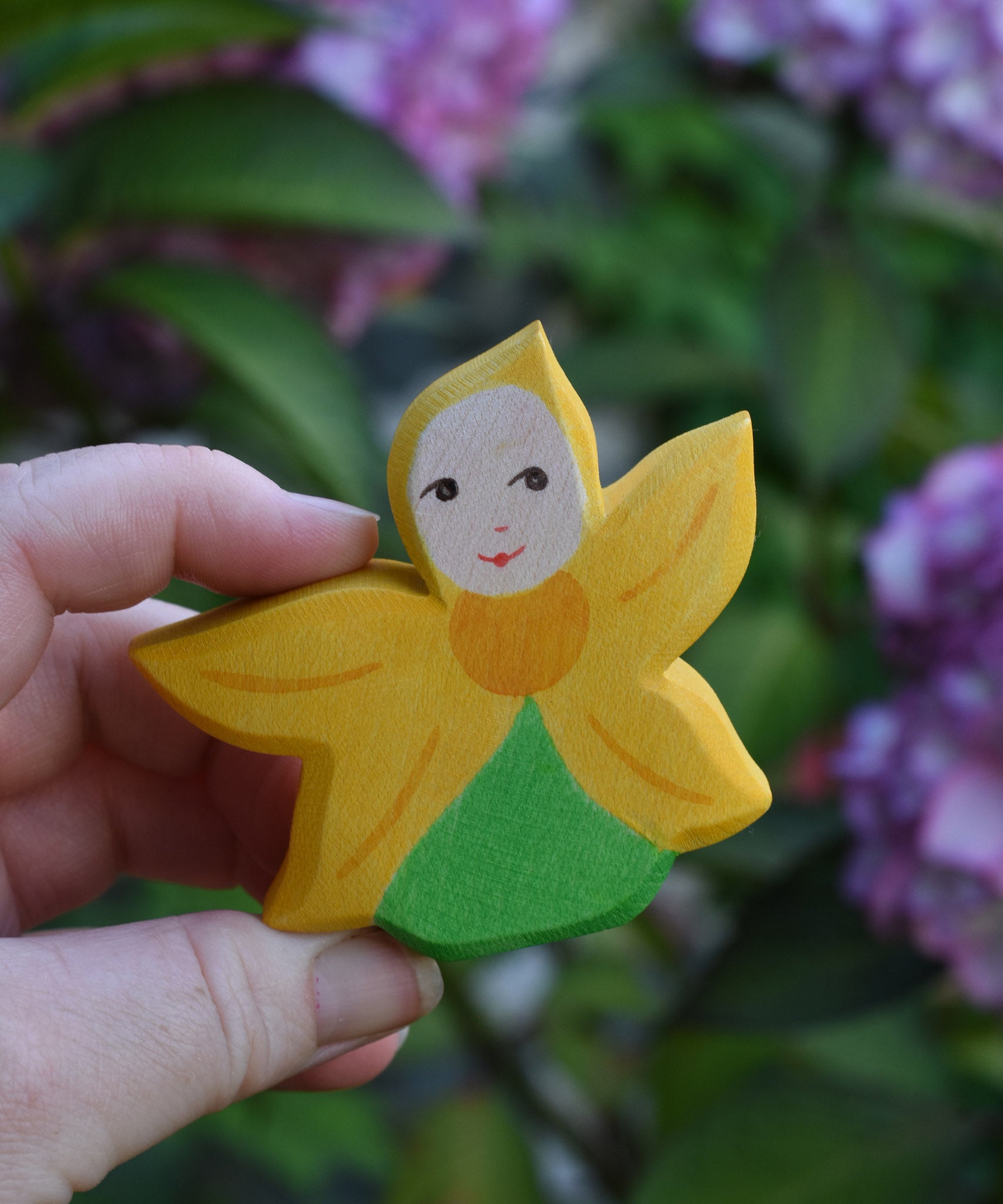 An Ostheimer Sunflower Flower Child being held in an adult's hand to show scale. This wooden figure is part of a large range of expertly hand crafted, Waldorf inspired, wooden toys here at Babipur. 
