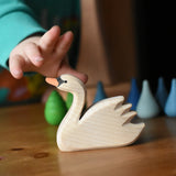 Ostheimer swan with high head placed on a wooden surface with Grapat mandala pieces in the background.