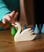 Ostheimer swan with high head placed on a wooden surface with Grapat mandala pieces in the background.