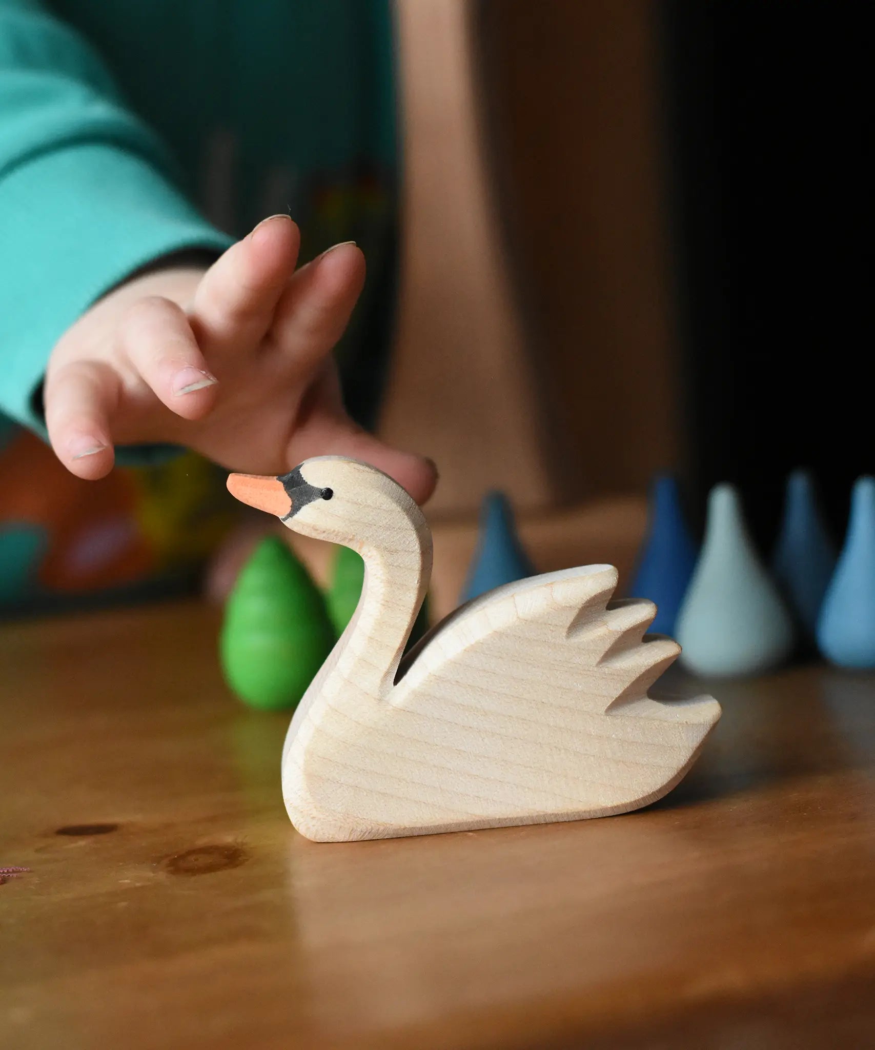 Ostheimer swan with high head placed on a wooden surface with Grapat mandala pieces in the background.