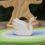 An Ostheimer Swan with High Neck wooden toy figure placed on a wooden pond scene piece.