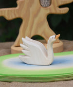 An Ostheimer Swan with High Neck wooden toy figure placed on a wooden pond scene piece.