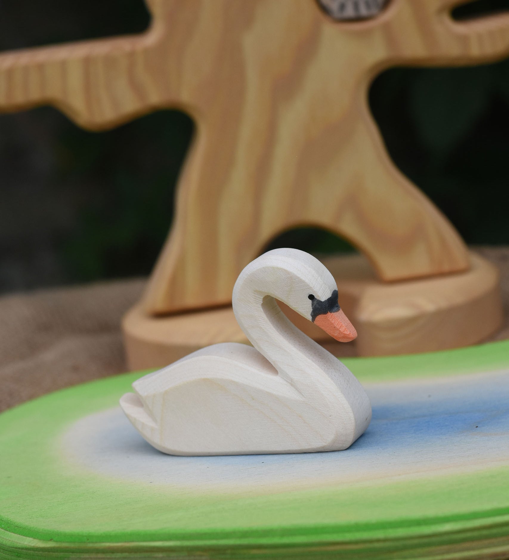 An Ostheimer white swan toy placed on a pond scene piece. 