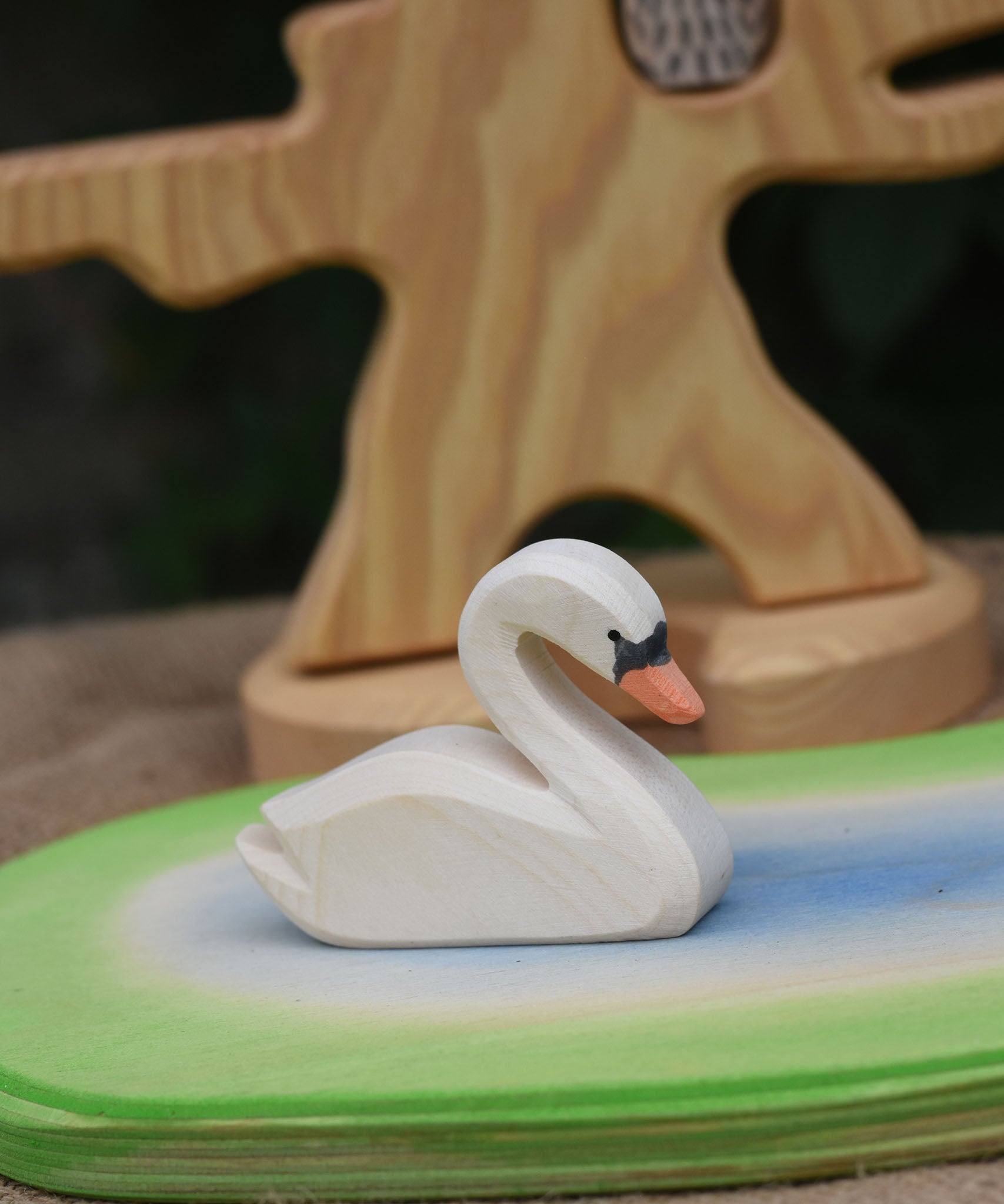 An Ostheimer white swan toy placed on a pond scene piece. 
