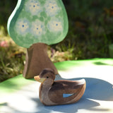 Ostheimer swimming duck placed on a pond piece with a pear tree in the background.