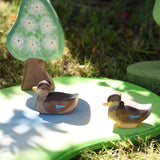 Ostheimer swimming and sitting ducks wooden toy figures placed on a pond piece.