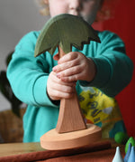 Child holding an Ostheimer tall palm tree in their hands.