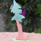 A tall Ostheimer spruce tree with support placed on a jute covered surface. 