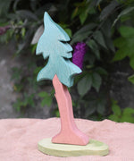 A tall Ostheimer spruce tree with support placed on a jute covered surface. 