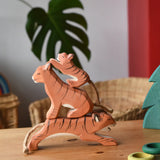 Ostheimer running, sitting and small lurking tiger wooden toy figures stacked up on top of each other.