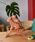 Ostheimer running, sitting and small lurking tiger wooden toy figures stacked up on top of each other.