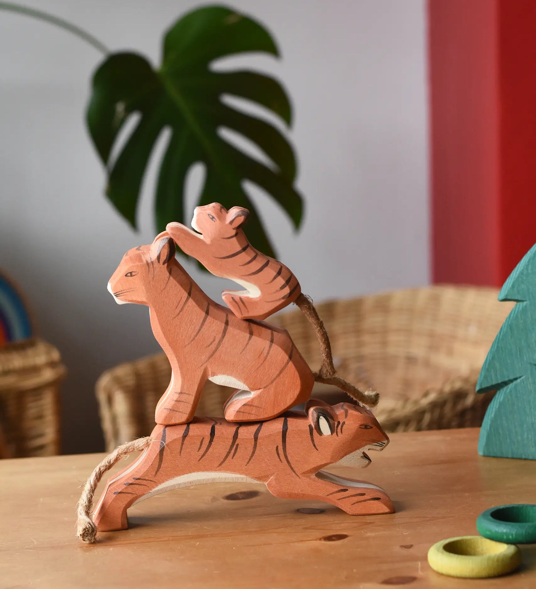 Ostheimer running, sitting and small lurking tiger wooden toy figures stacked up on top of each other.