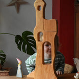 Ostheimer tower with stairs wooden toy building with a child standing  large behind and peering through the window.