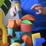 Ostheimer Rainbow Castle Block set played with by a child placing a blue king wooden figure on the blocks.