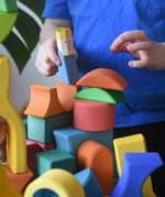 Ostheimer Rainbow Castle Block set played with by a child placing a blue king wooden figure on the blocks.
