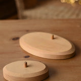 Ostheimer palm tree wooden support base placed on a wooden surface with the larger group base in the background.