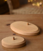 Ostheimer palm tree wooden support base placed on a wooden surface with the larger group base in the background.
